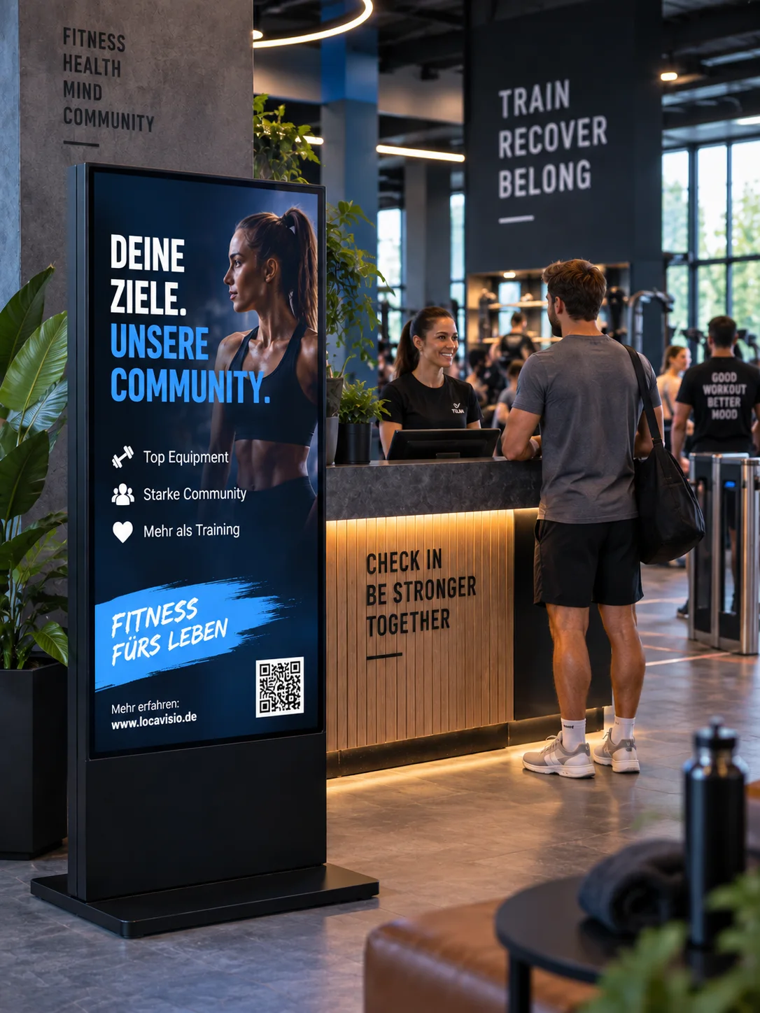Digital Signage im Fitnessstudio: Displaystele im Eingangsbereich neben dem Empfangstresen.